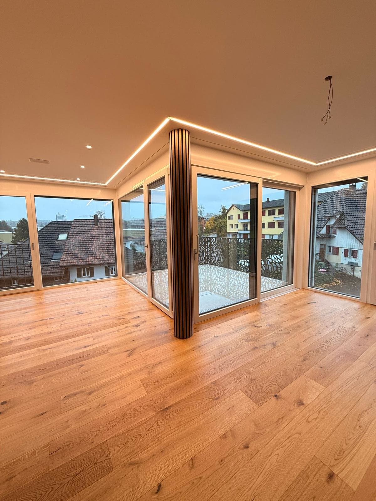 Eichenparkett in einem Wohnraum mit Eckverglasung und Balkon