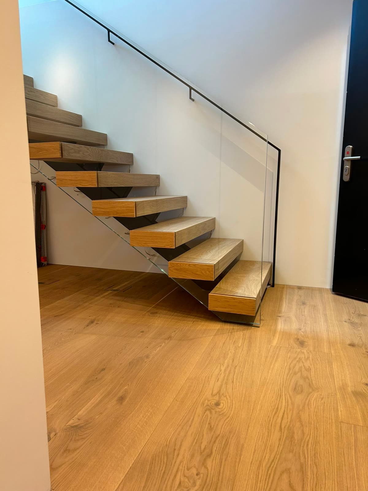 Schwebende Treppe mit Glasgeländer auf Eichenparkett