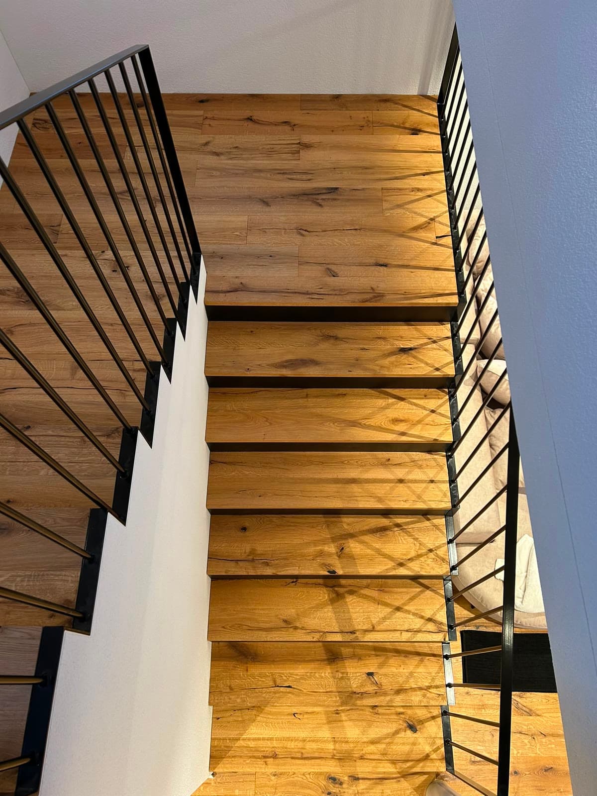 Moderne Eichentreppe mit schwarzem Stahlgeländer